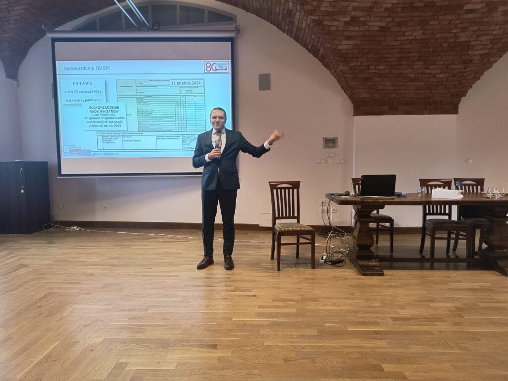 Zastępca Dyrektora Departamentu Informacji o Nieruchomościach Szymon Szczerba wygłasza prezentację pt. "Sprawozdnie GUGiK vs GML"