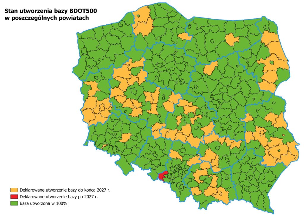 Ilustracja przedstawia mapę Polski obrazującą stan utworzenia baz danych BDOT500 w poszczególnych powiatach kraju. Na zielono zaznaczono powiaty w których baza danych BDOT500 jest utworzona w pełni, na żółto zaznaczono powiaty które deklarują utworzenie bazy danych do końca 2027 r., natomiast na czerwono zaznaczono powiaty, które deklarują utworzenie bazy danych po 2027 r.