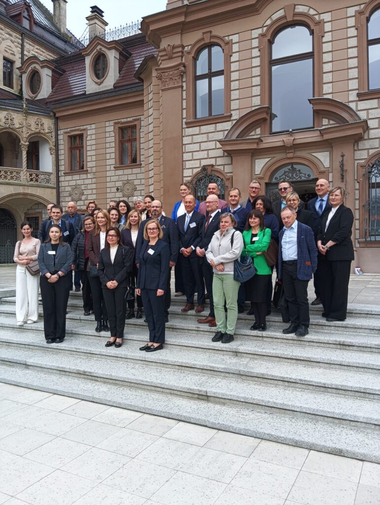 ilustracja przedstawia zdjęcie uczestników spotkania przed Zamkiem w Mosznej.