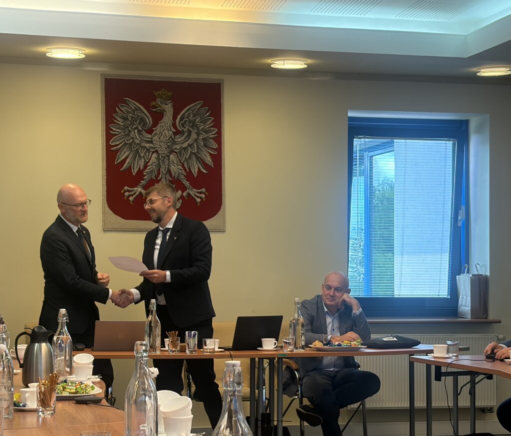 dr hab. inż. Paweł Hanus, prof. AGH składa na ręce Głównego Geodety Kraju Andrzeja Żylisa rezygnację z funkcji przewodniczącego PRGiK